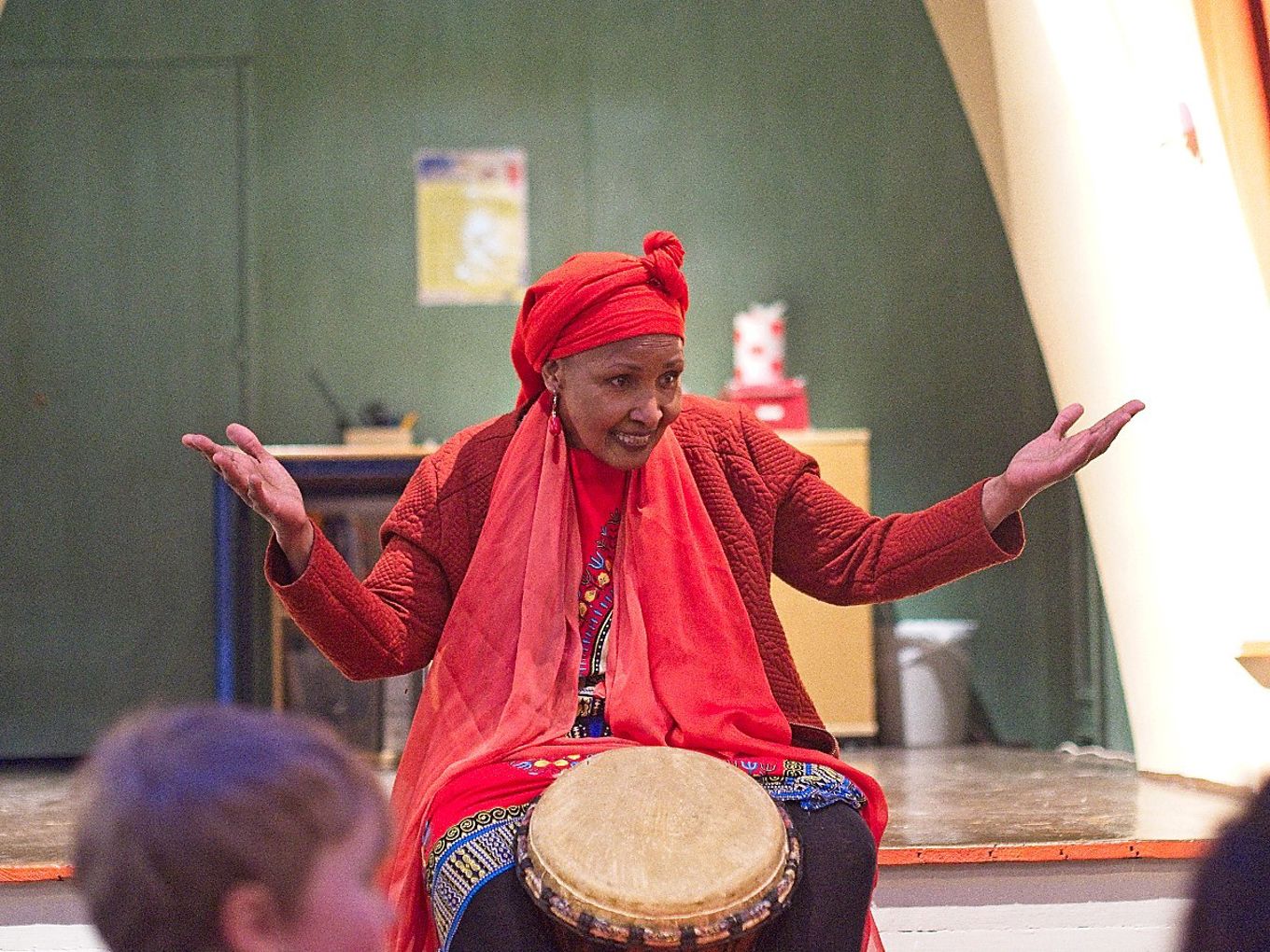 en person som har på seg en rød hatt og holder hendene opp